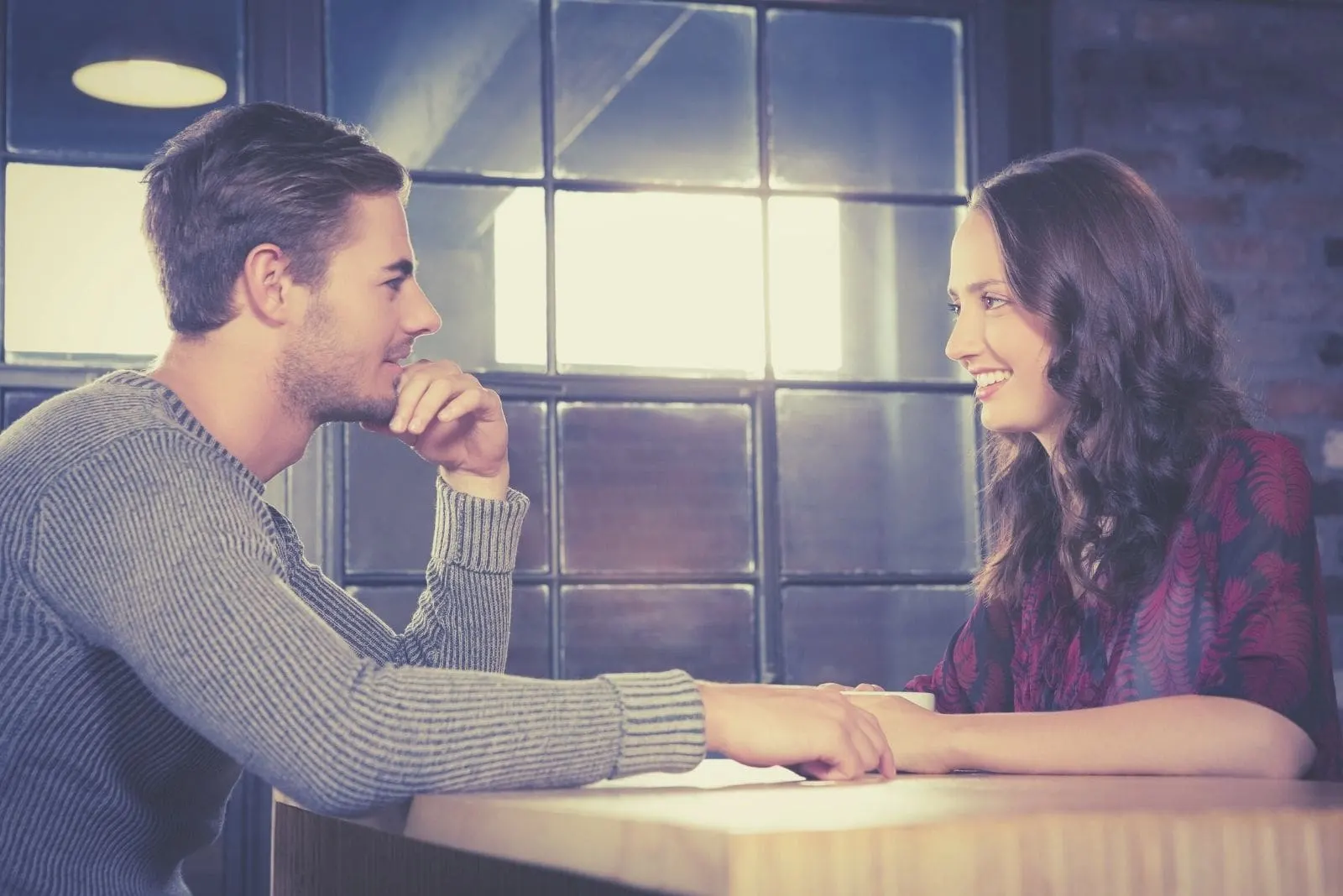 dating couple talking and smiling at a restaurant