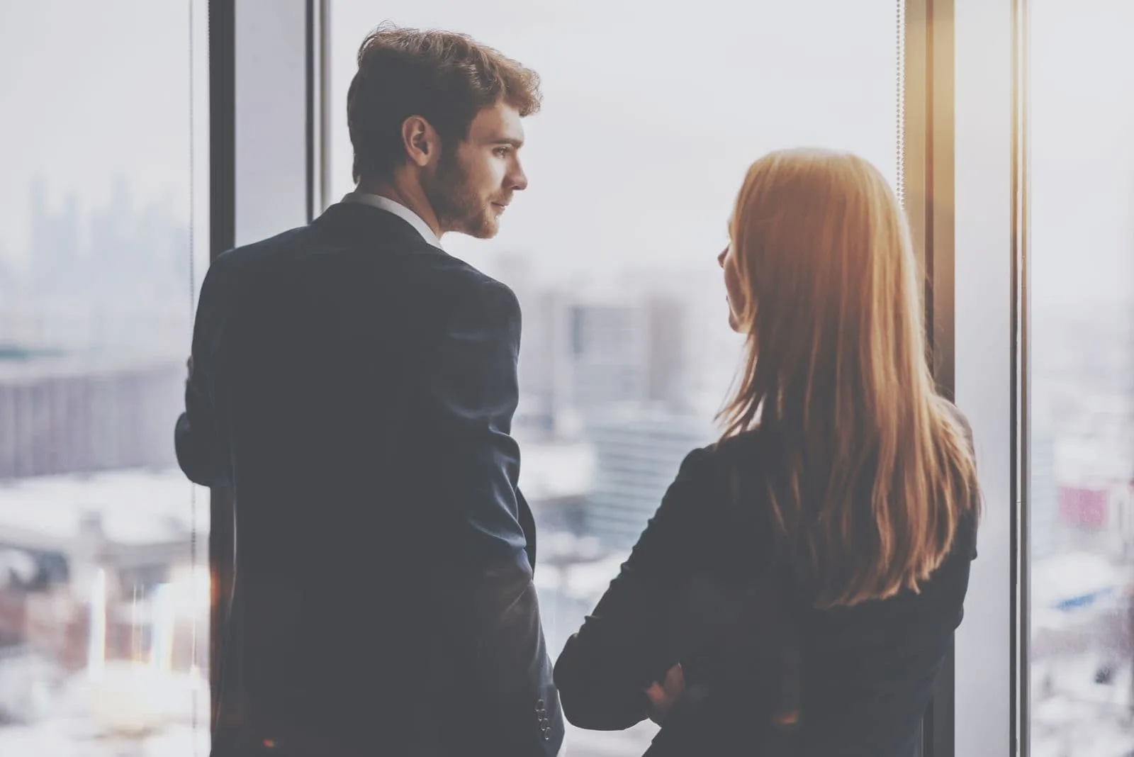 female co worker talking to her colleague facing outside the building