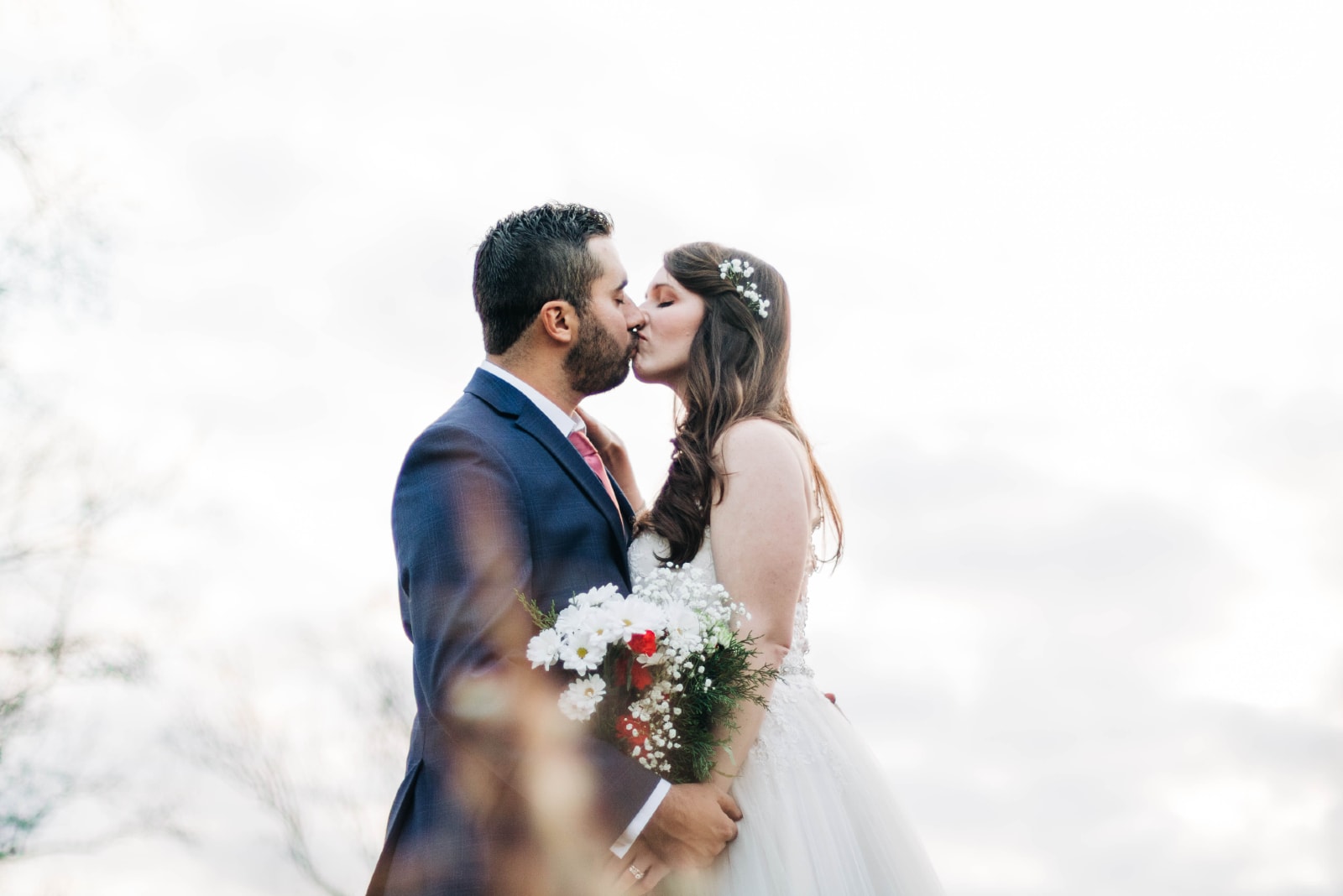 groom and bride kissing while standing outdoor