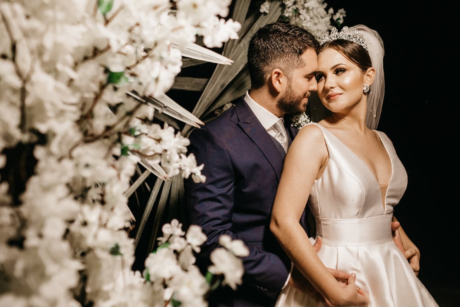 groom and bride making eye contact while standing near flowers