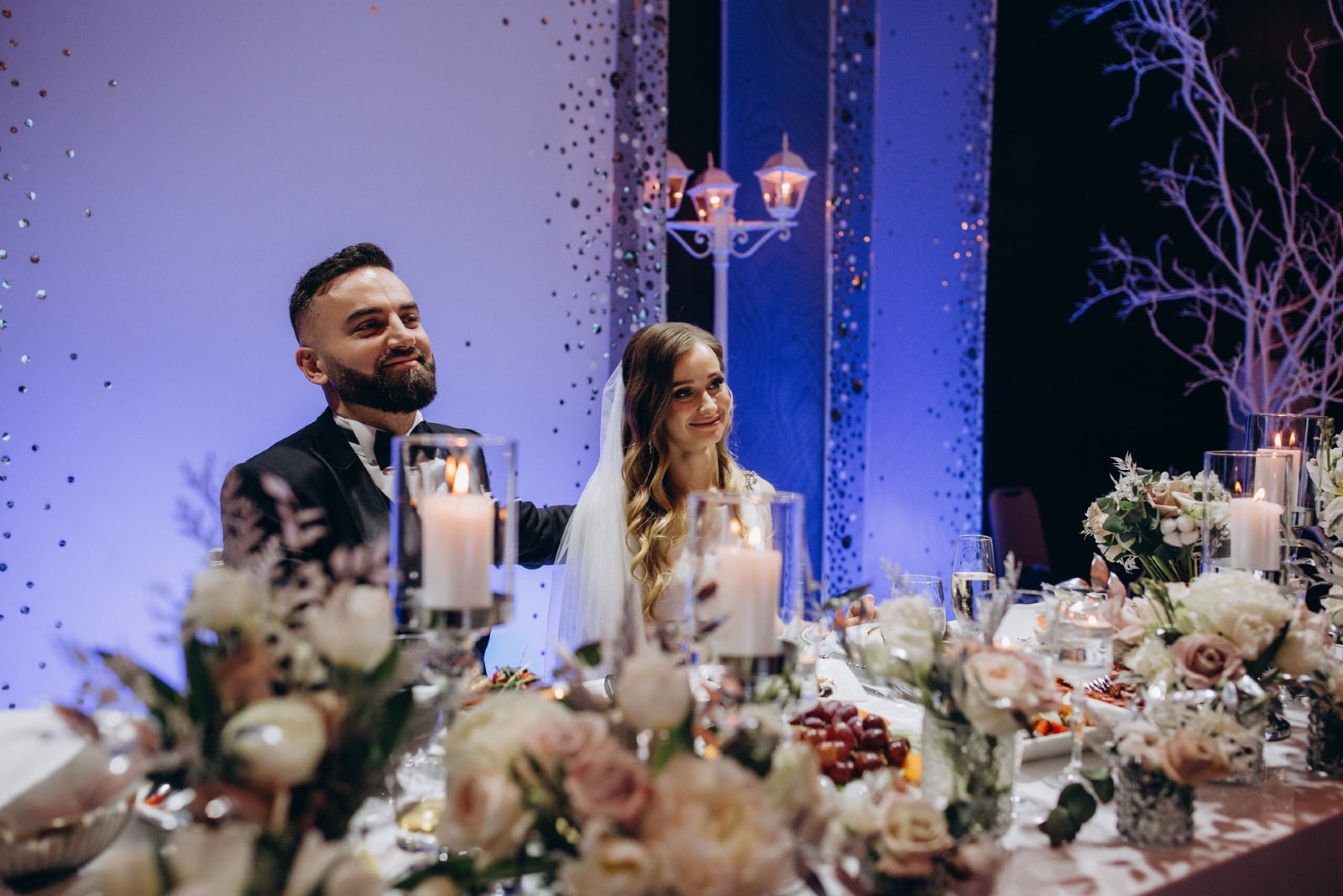 happy groom and bride sitting at wedding table