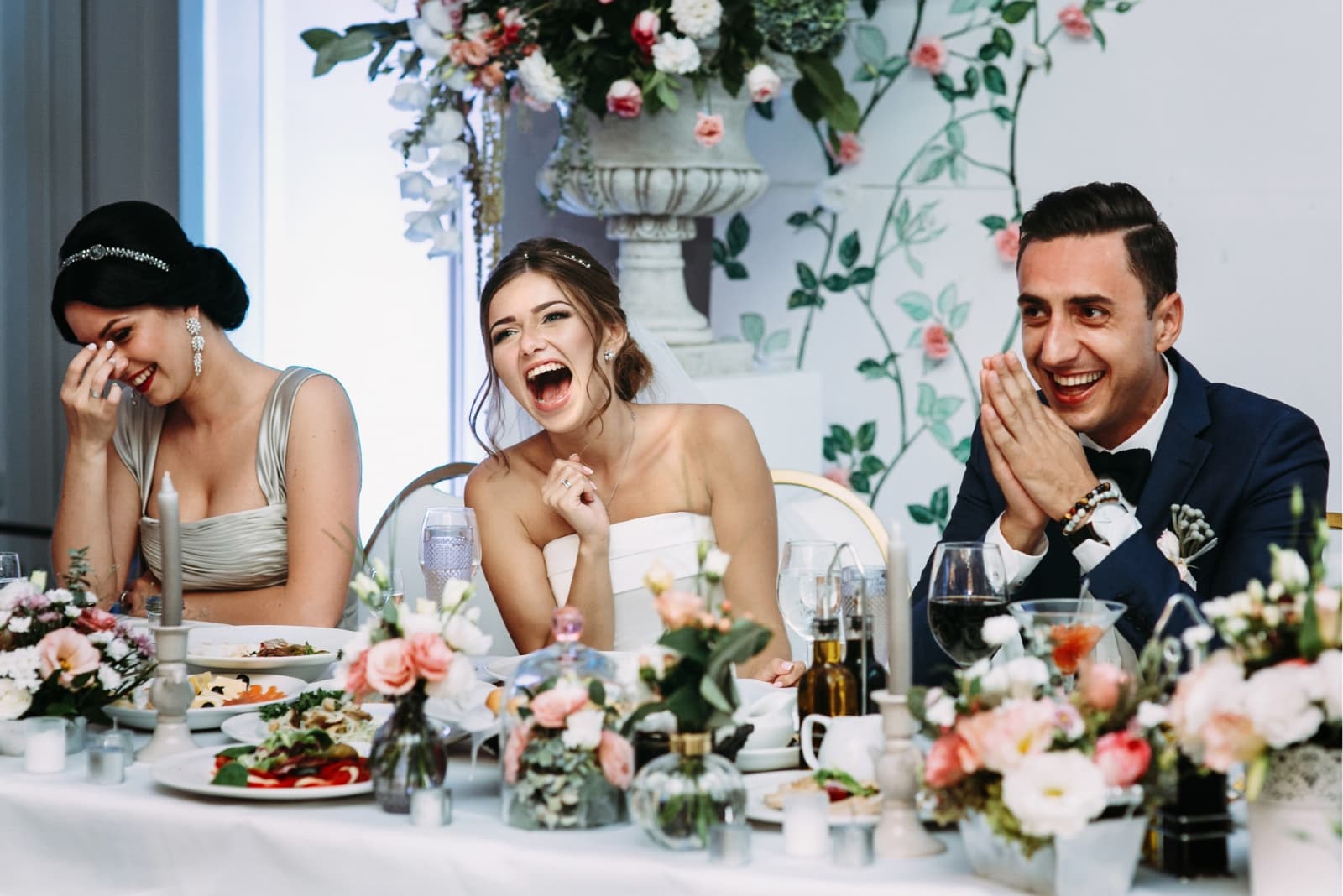 groom and bride smiling while sitting at wedding table