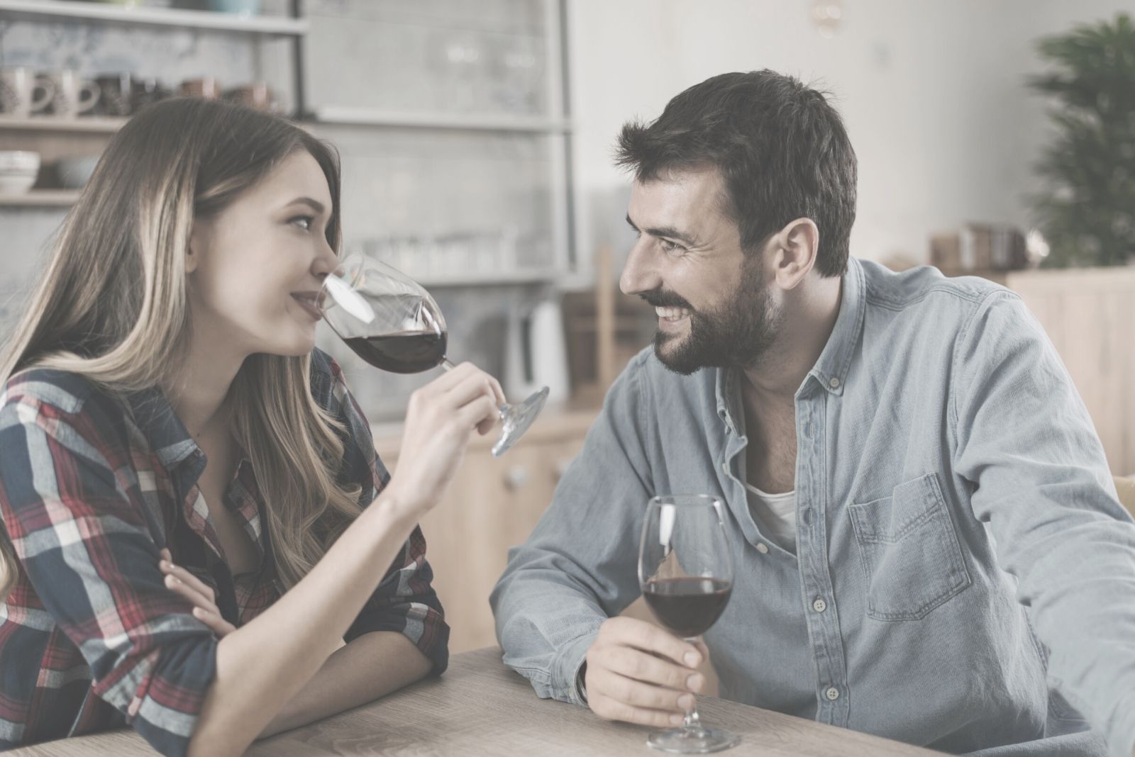 pareja feliz bebiendo vino en su casa