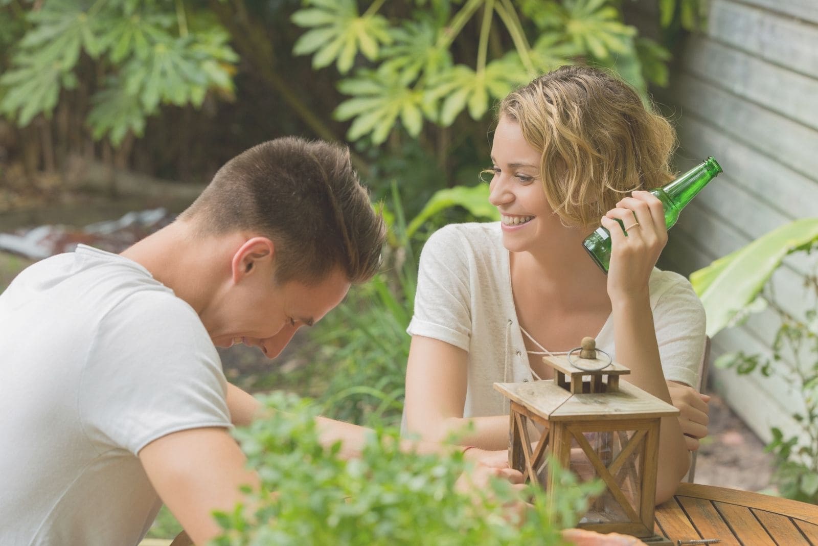 happy couple drinking beer outdoors laughing 