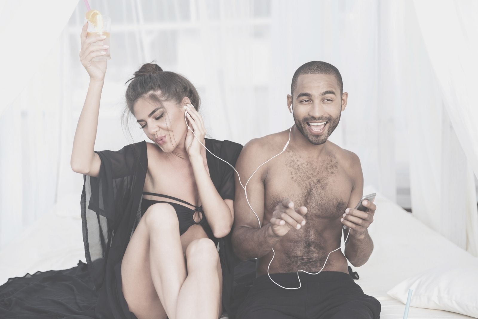 pareja feliz cantando mientras escucha sus auriculares en la playa