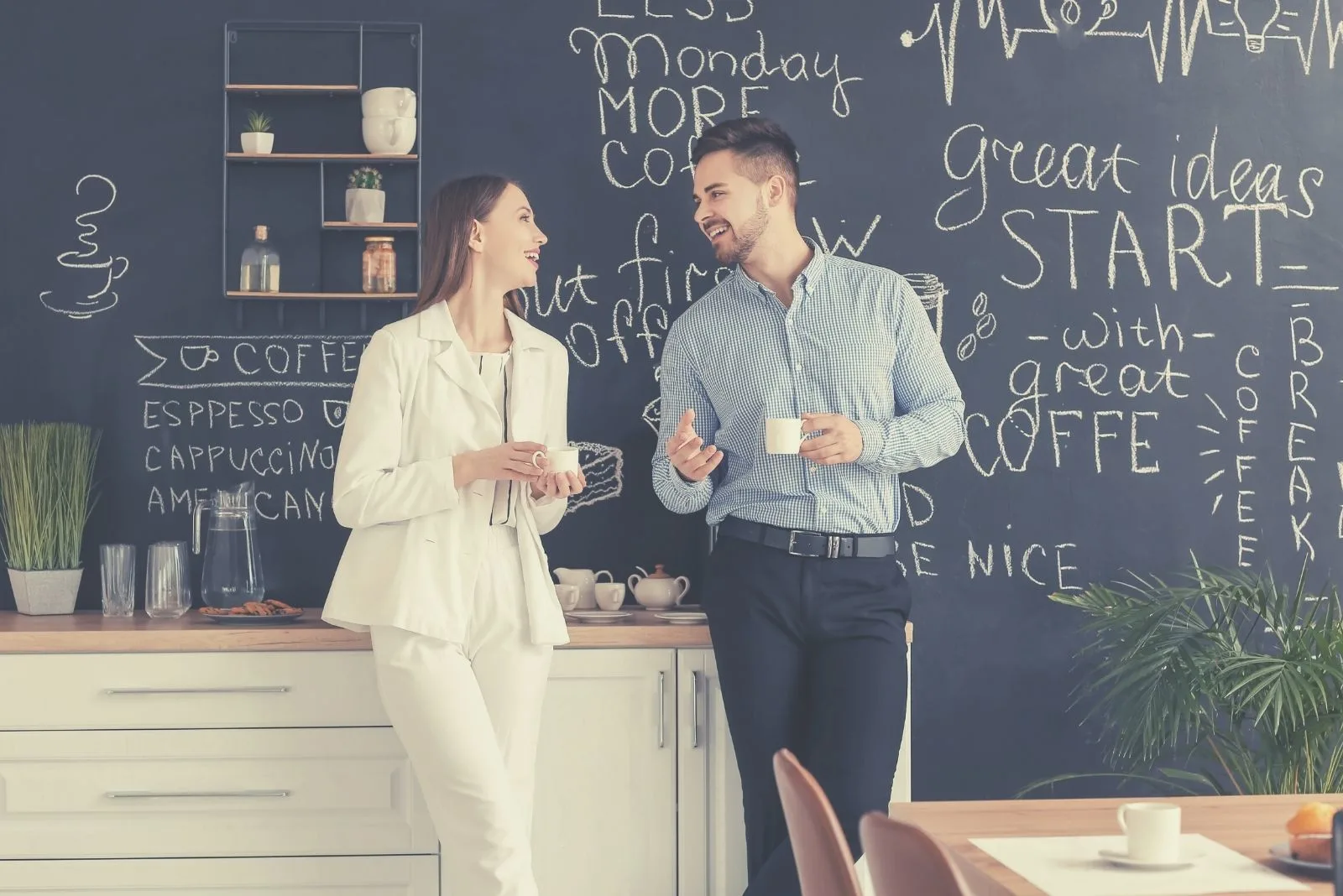 male and female workers drinking coffee in the pantry during their break