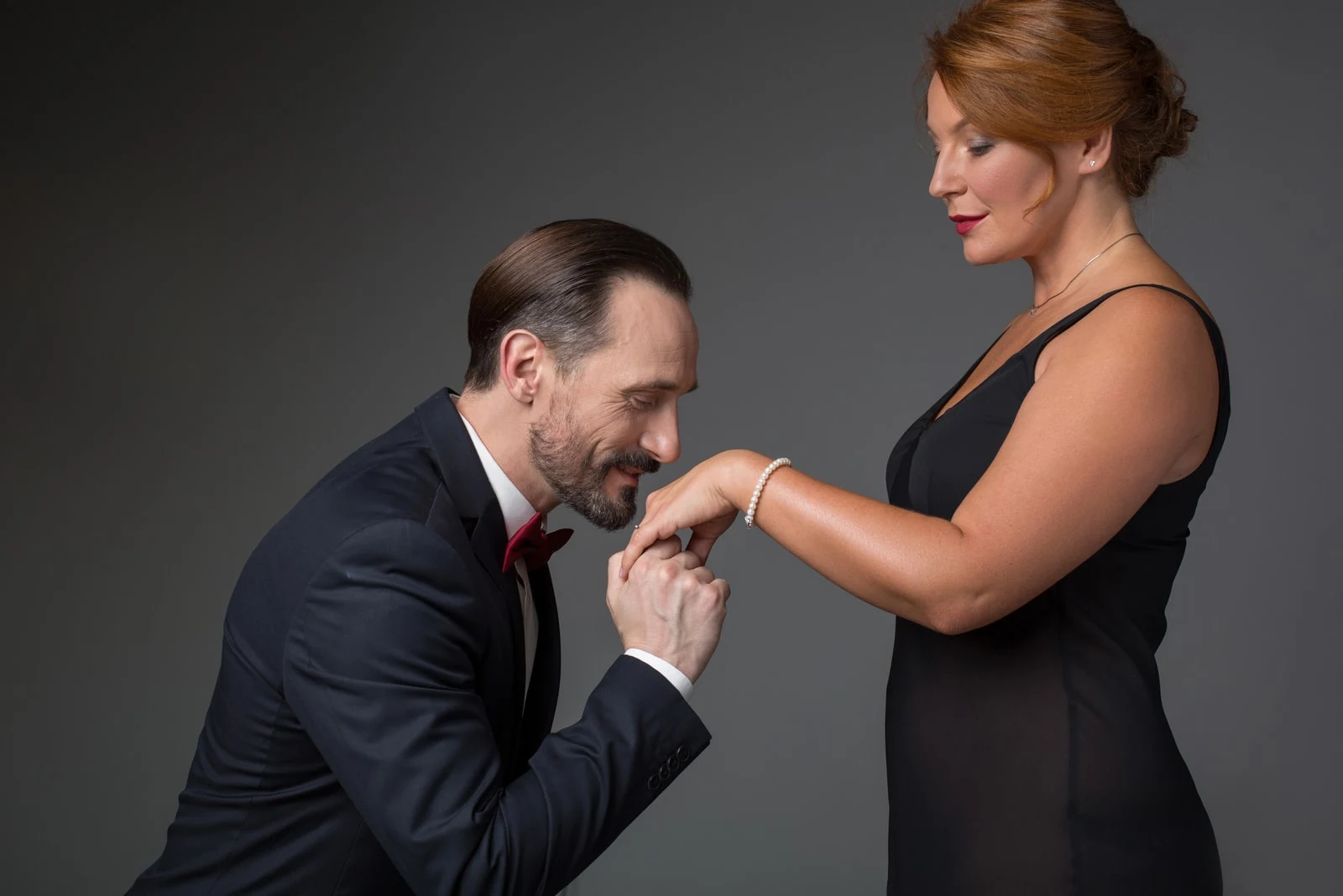 man holding female hand with gold ring and kissing it.