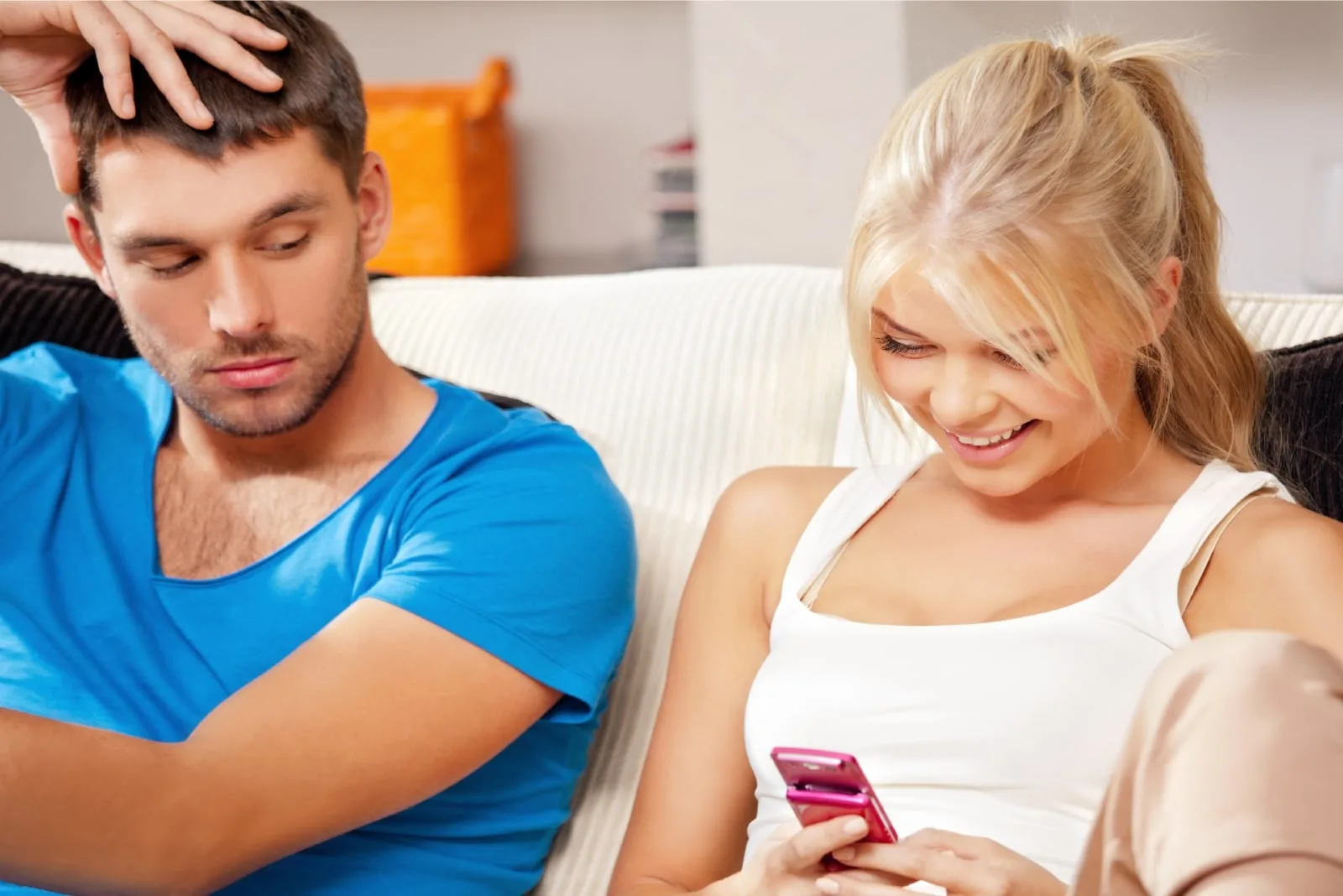 man looking at woman's phone while sitting on sofa