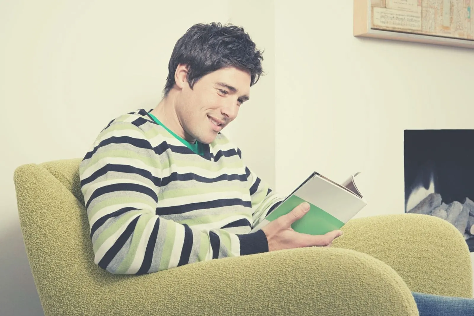 man reading book alone while sitting in the nook