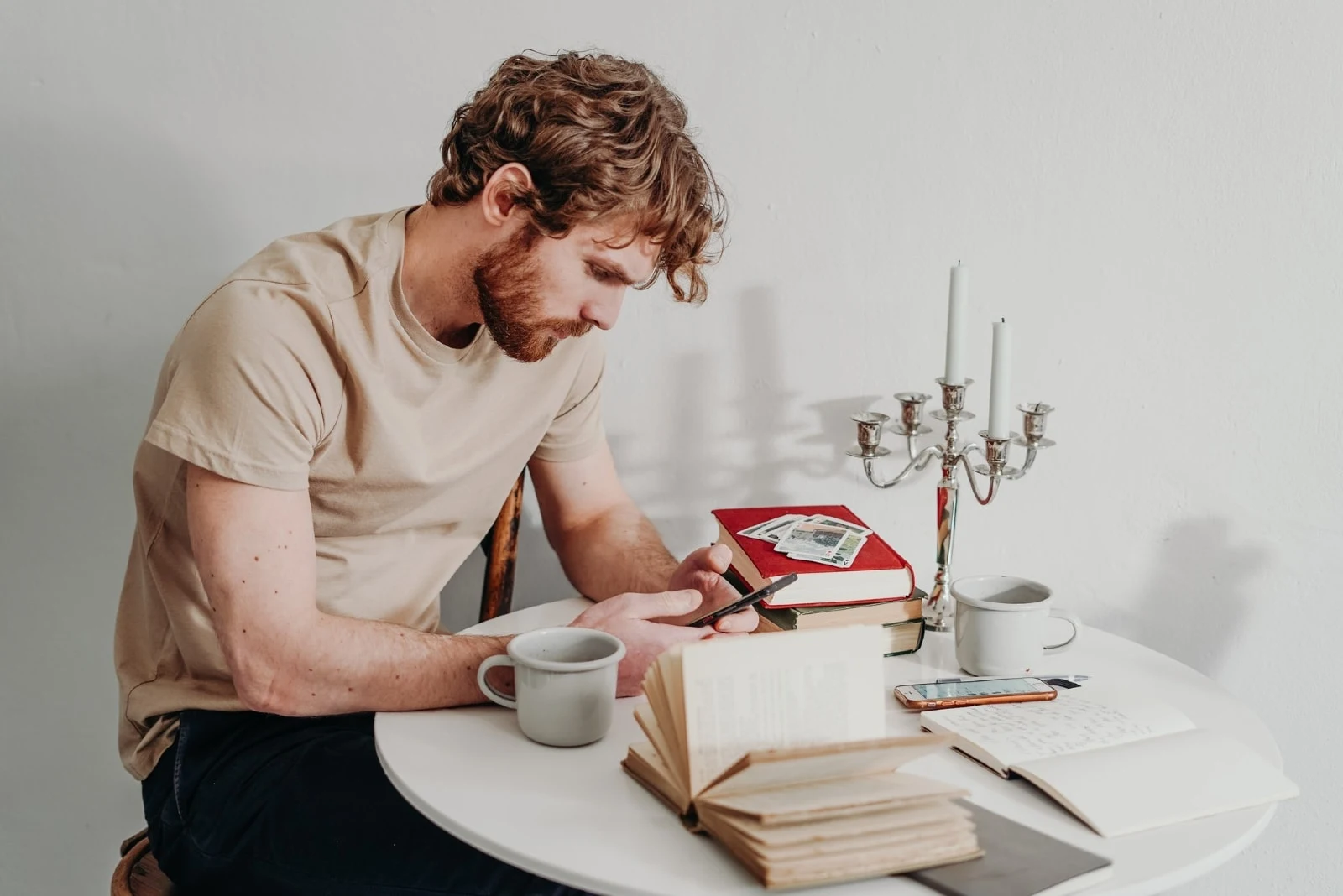 man using phone while sitting at table