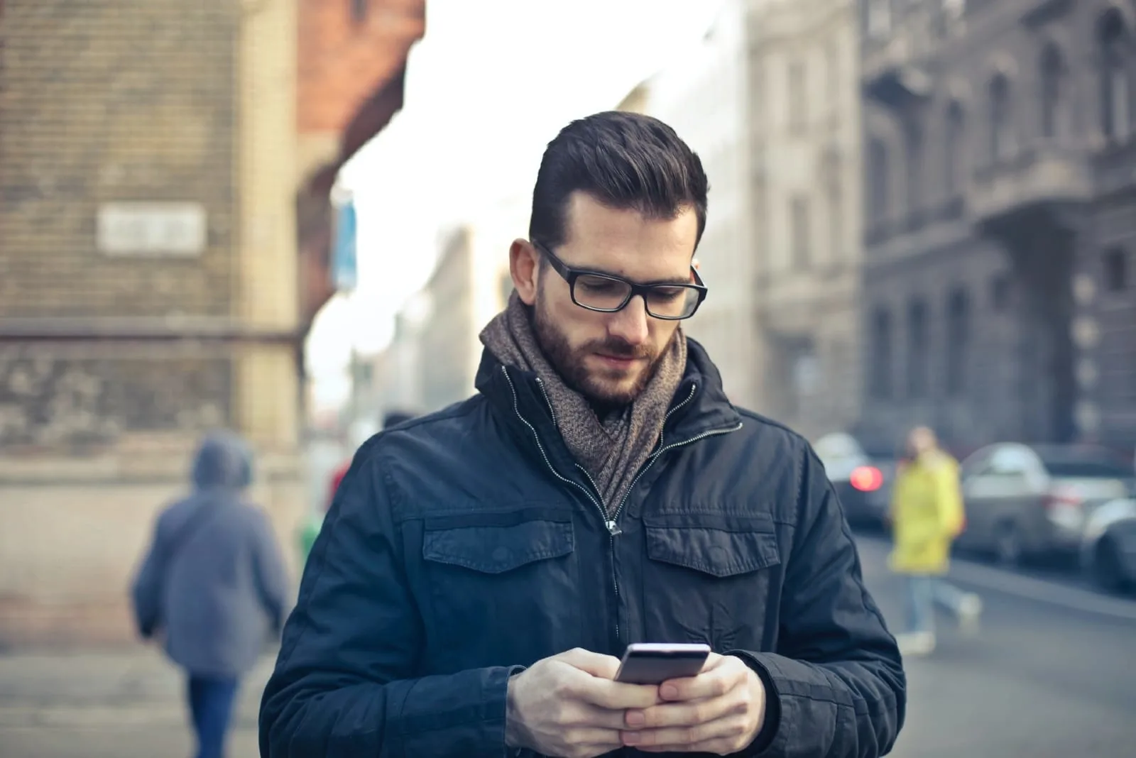 man with eyeglasses using smartphone