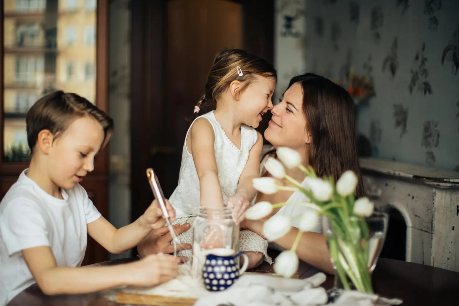 mother playing with children while sitting at table
