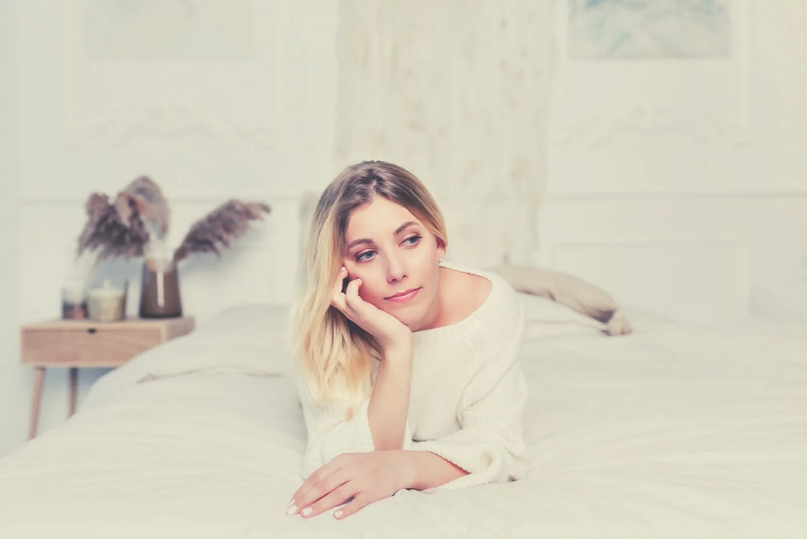portrait of a thoughtful beautiful woman lying in bed