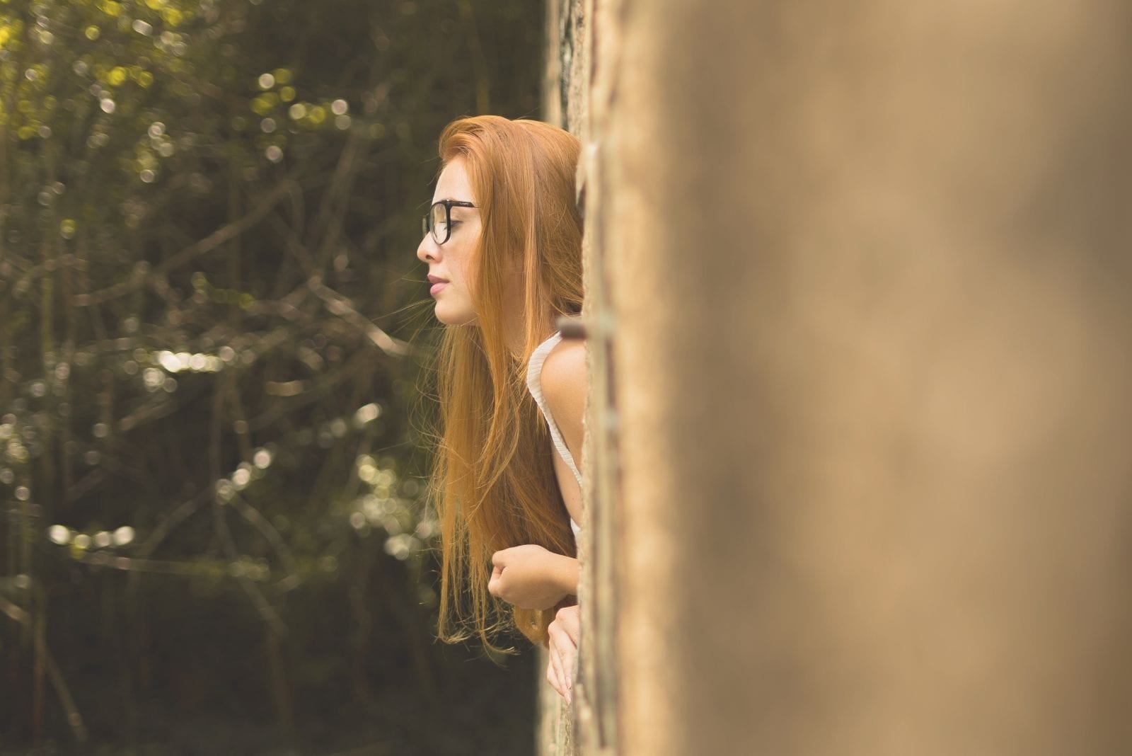 selective photo of a woman with half the body leaning outside the window