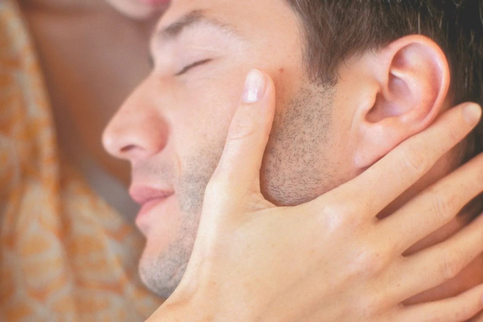 sweet couple snuggling with man's eyes closed 