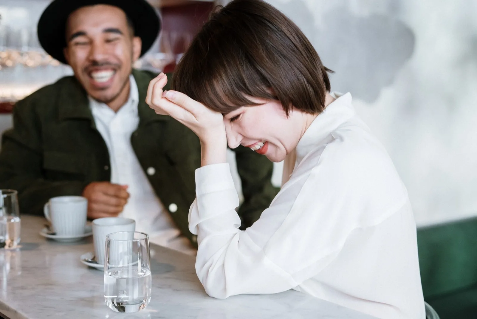 woman in white shirt laughing while sitting near man