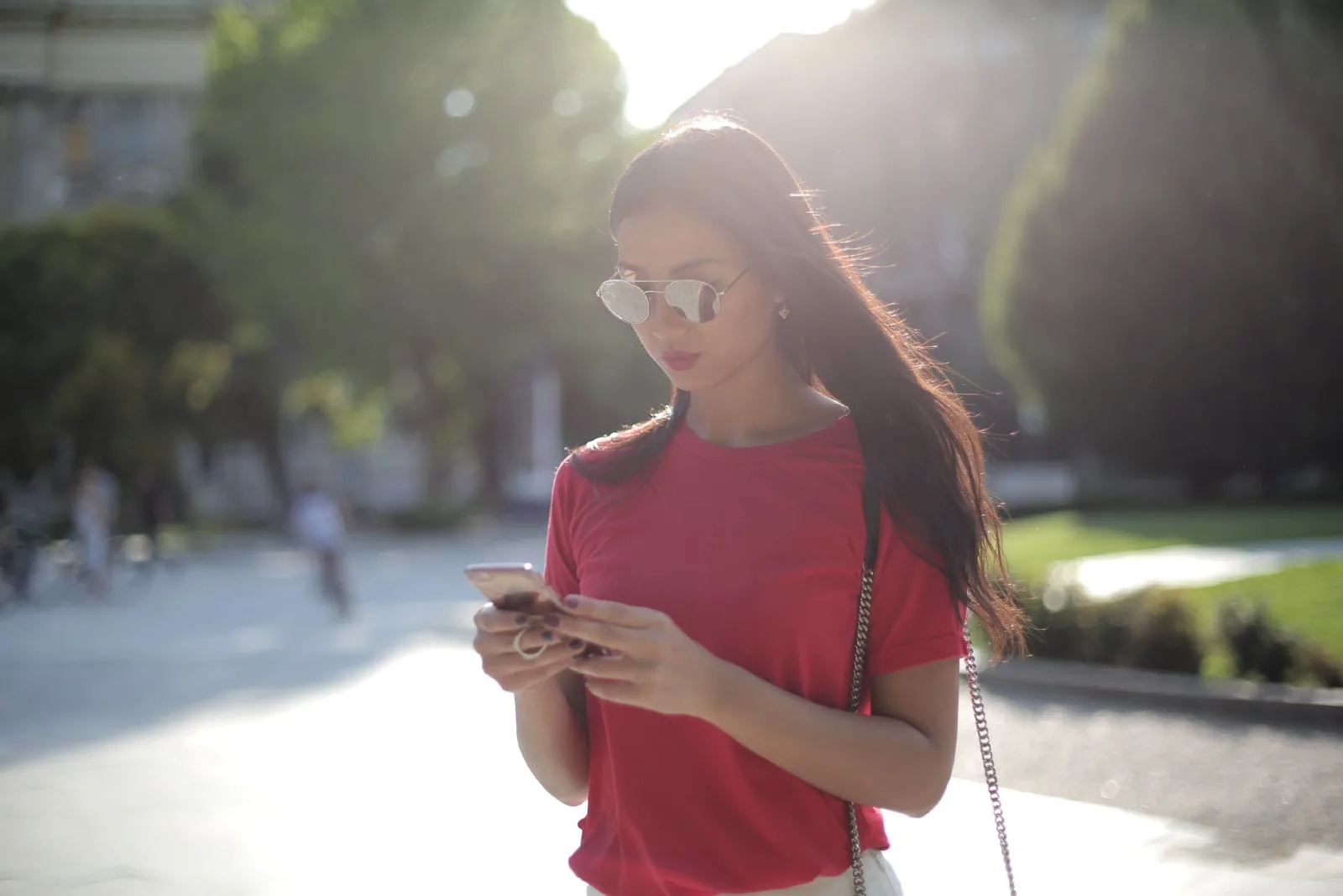 woman in red t-shirt looking at phone