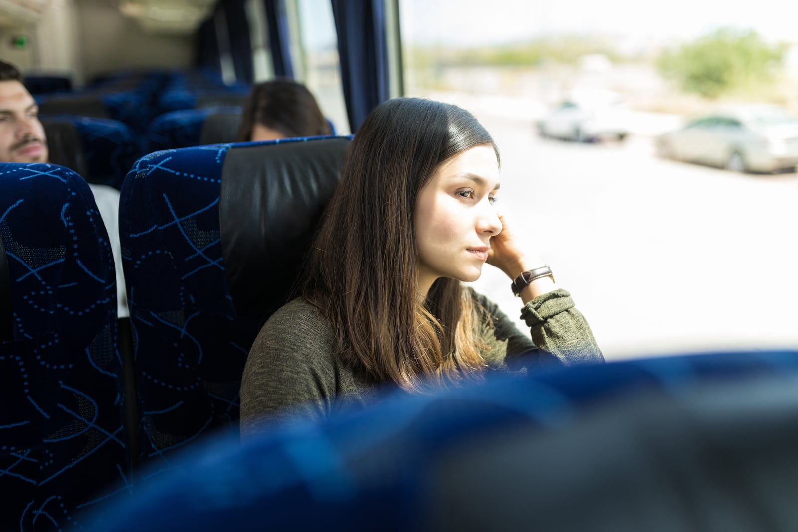 woman looking through window while traveling in bus