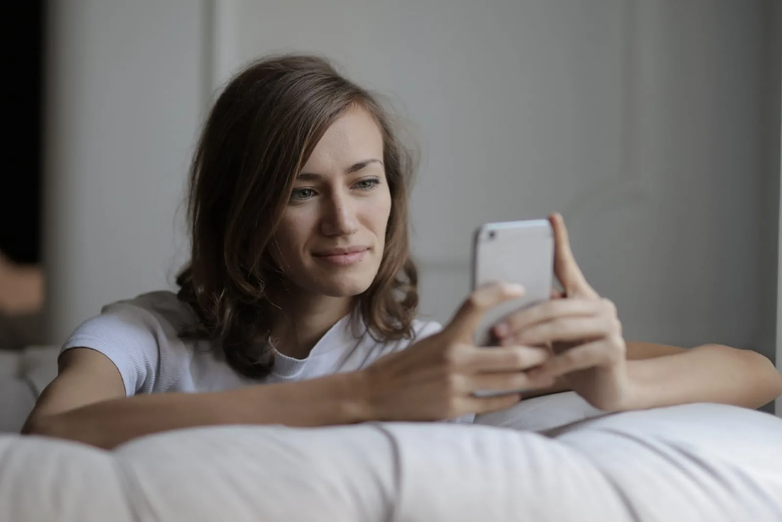 woman using smartphone while sitting on sofa