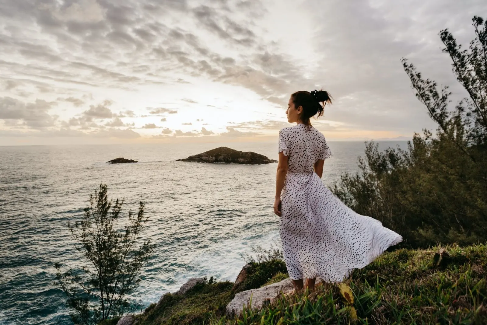woman in white printed dress standing near sea