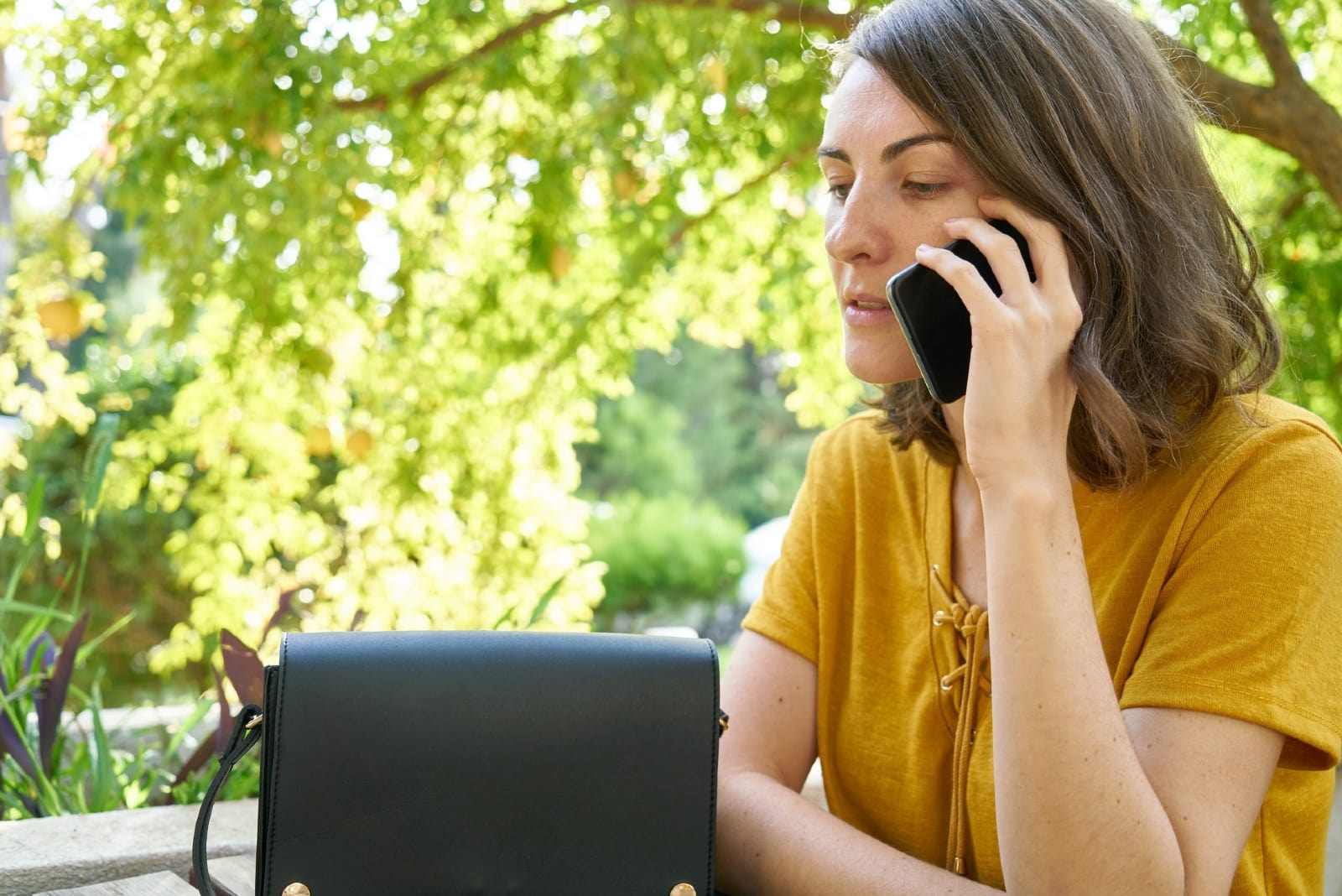 mujer hablando por teléfono sentada a la mesa