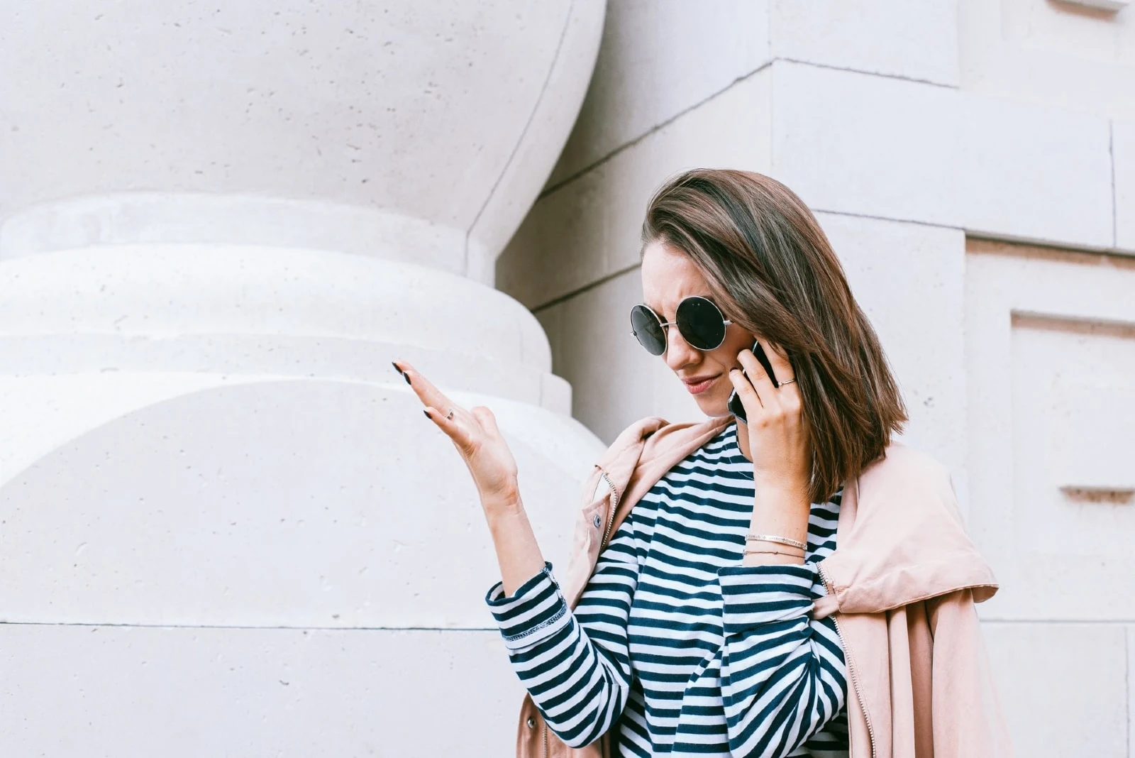 woman in striped shirt talking on the phone outdoor