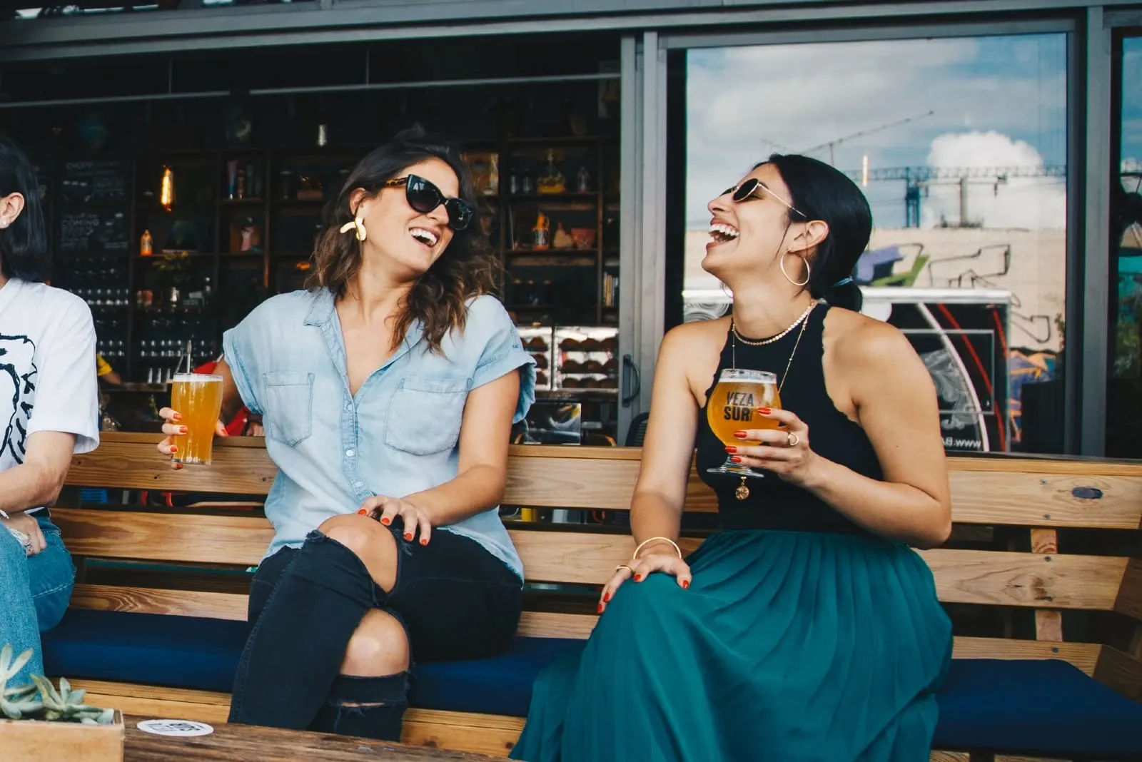 two women smiling while drinking beer