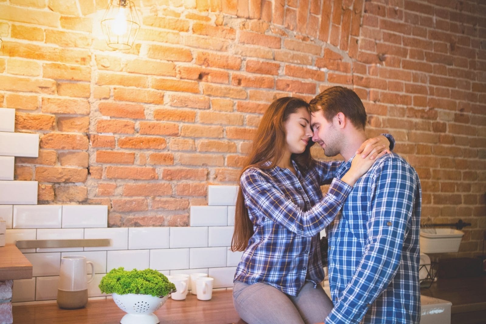 joven pareja abrazándose en la cocina 