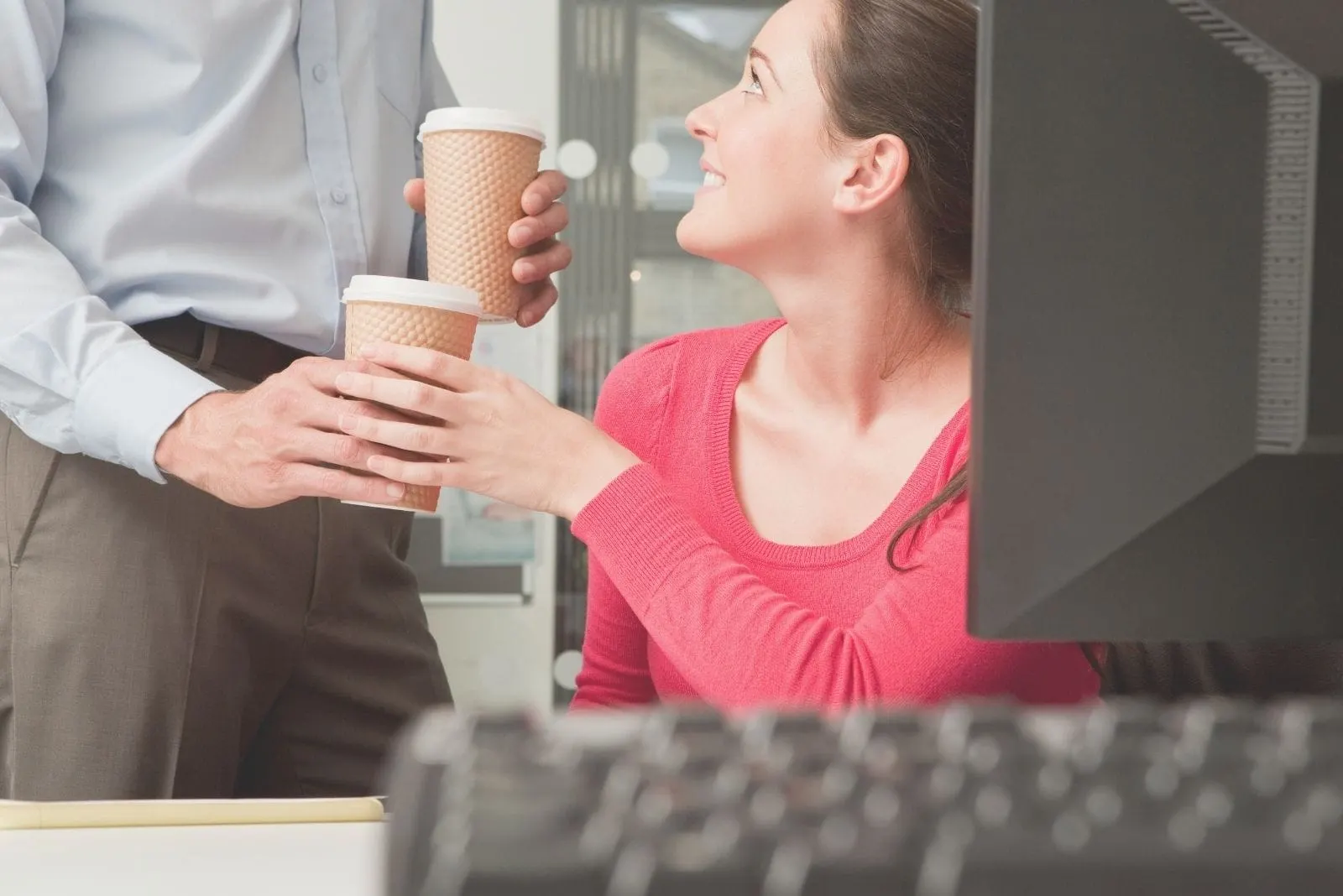 young man giving coffee to his colleague in the office