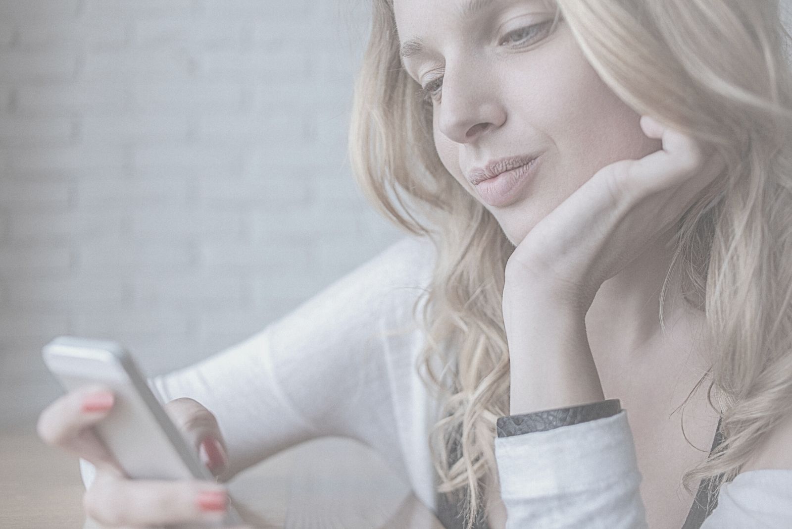 young pensive woman texting on the phone on close up photography