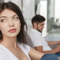 pensive woman in white t-shirt sitting near man