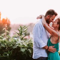 man and woman hugging while standing near plants