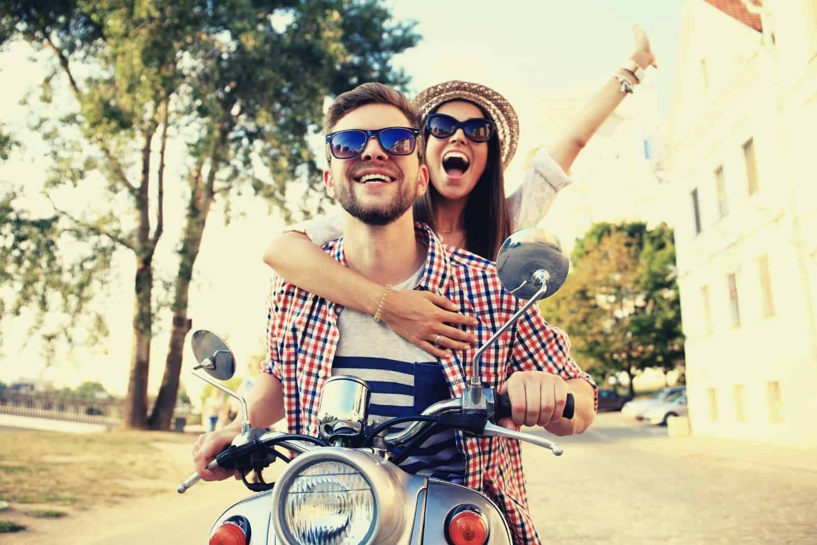 couple in love riding a motorcycle in the street in borad daylight