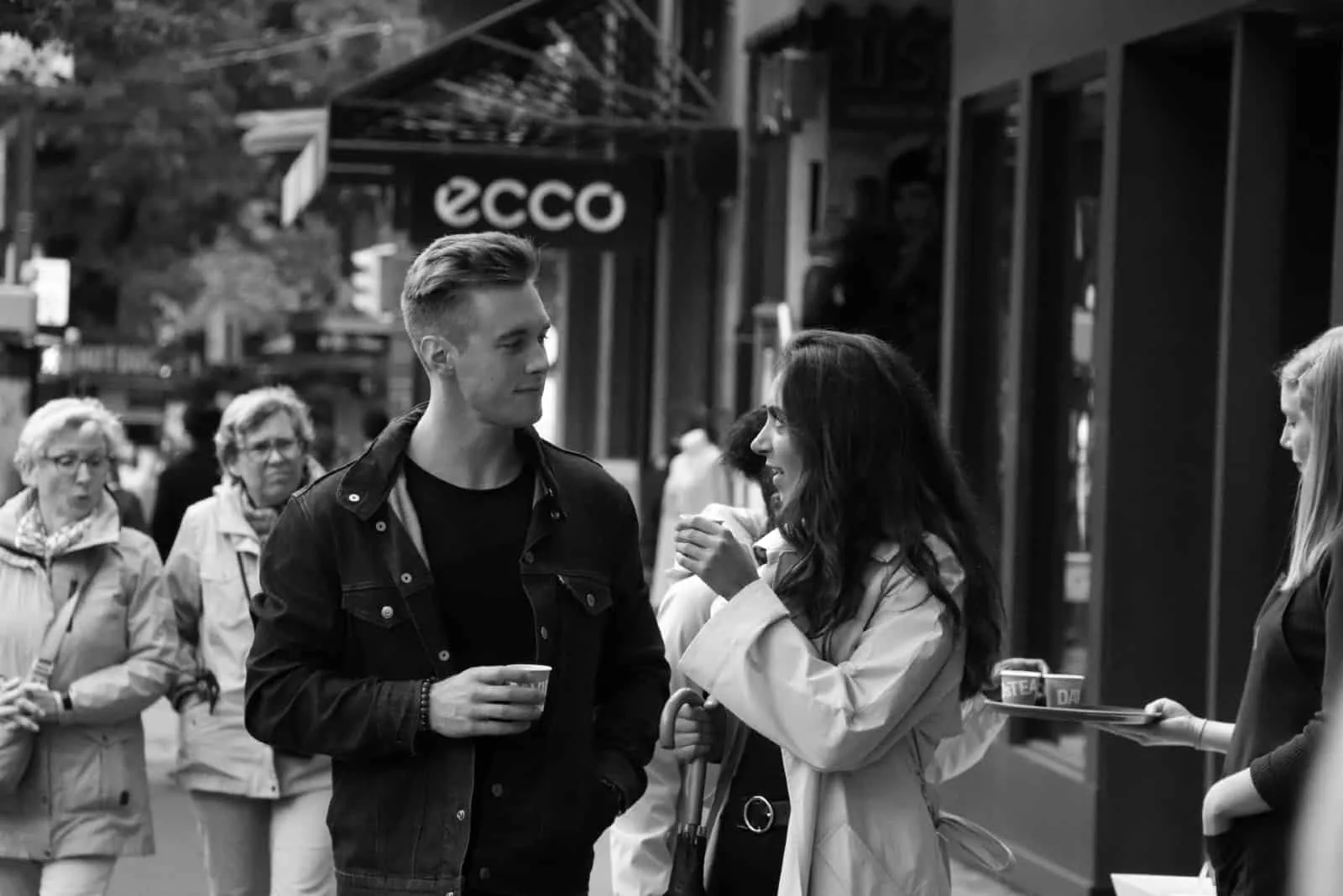 man and woman making eye contact while having coffee outdoor