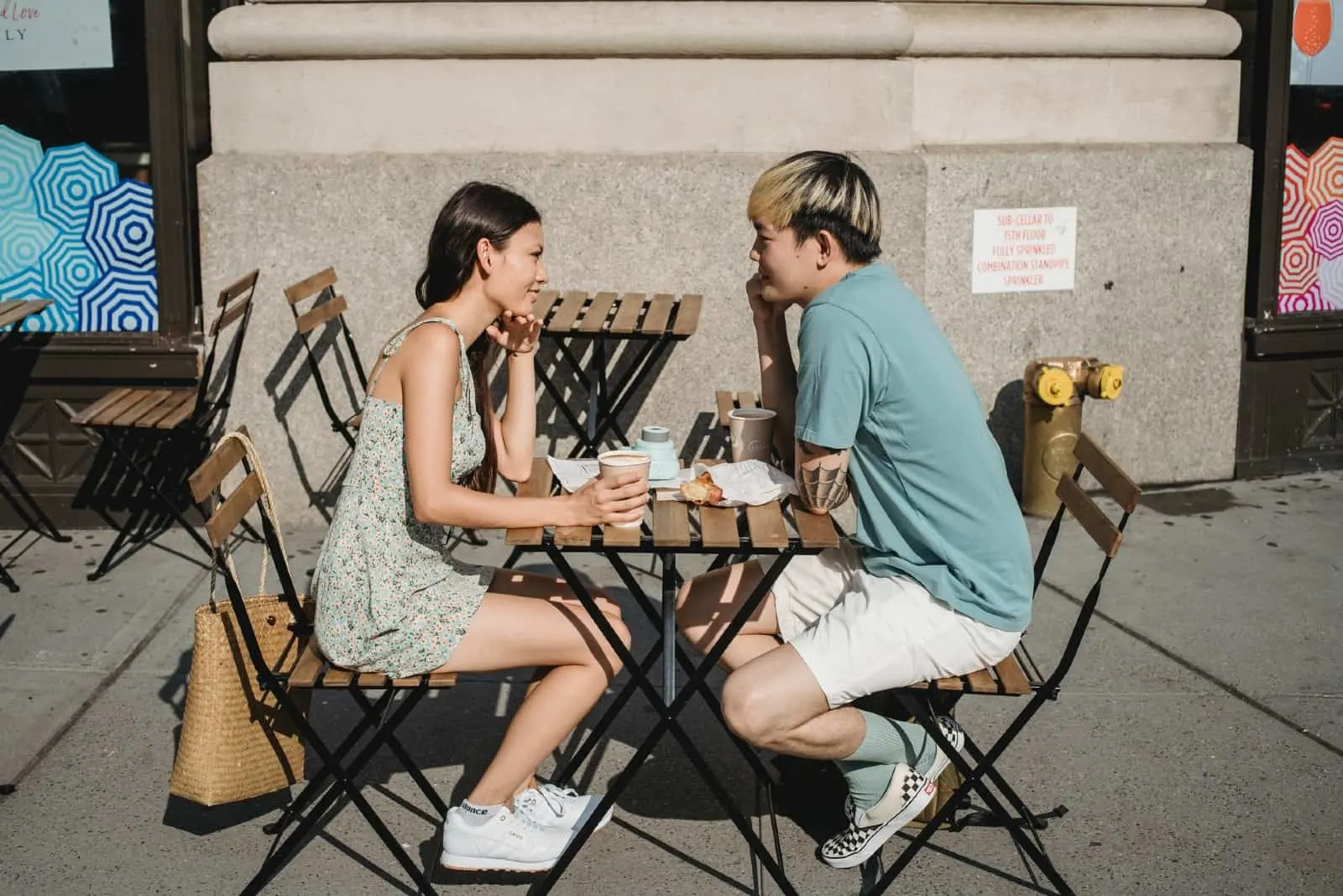 man and woman making eye contact while sitting at table outdoor