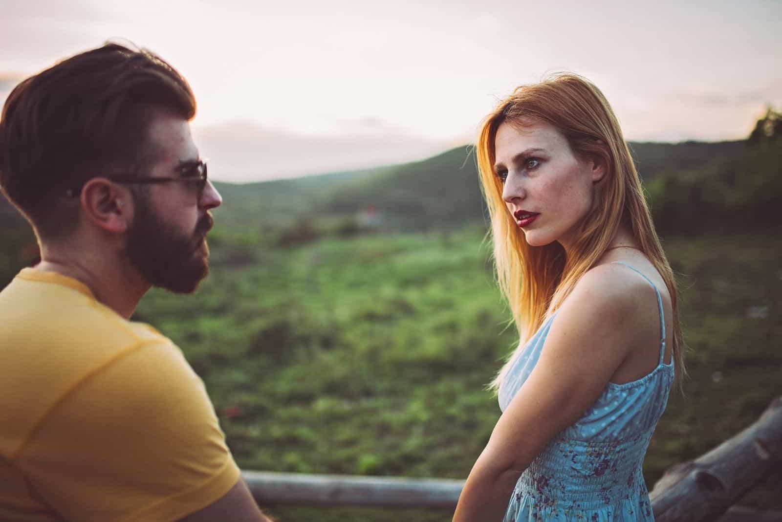 casal conversa séria ao ar livre no campo