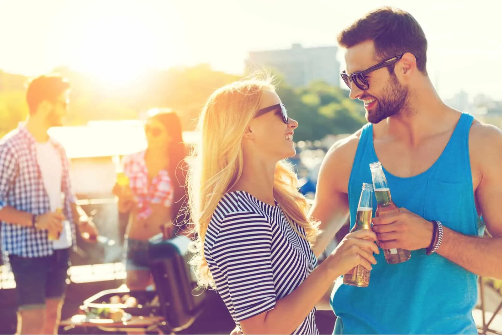 homme et femme souriant en buvant des boissons en plein air