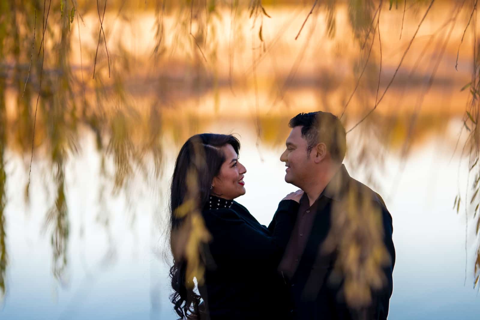 man and woman making eye contact while standing near water