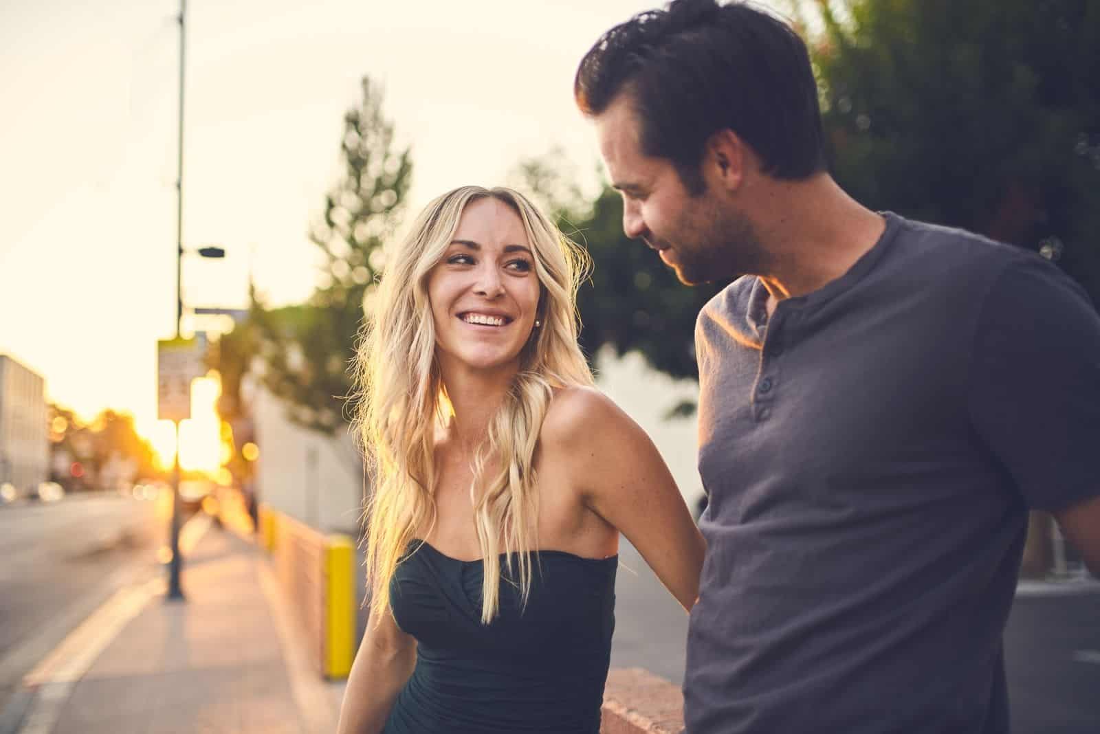 casal a conversar na rua, lado a lado, de manhã cedo