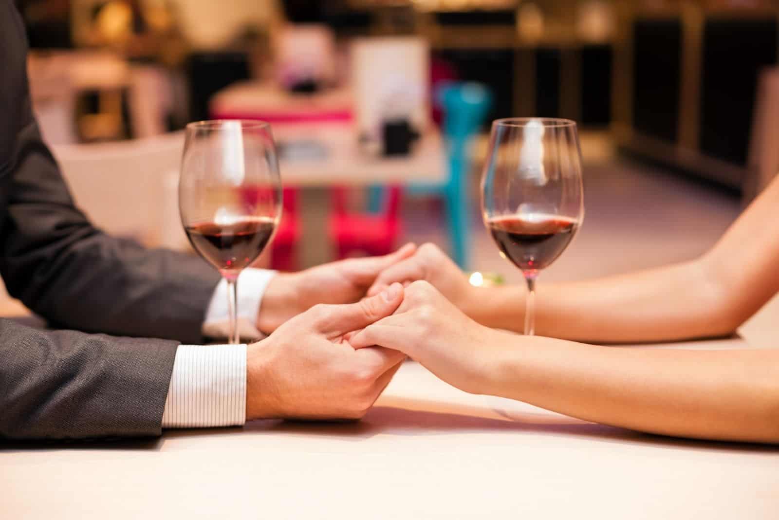 focus image on holding hands of a couple during a dinner date