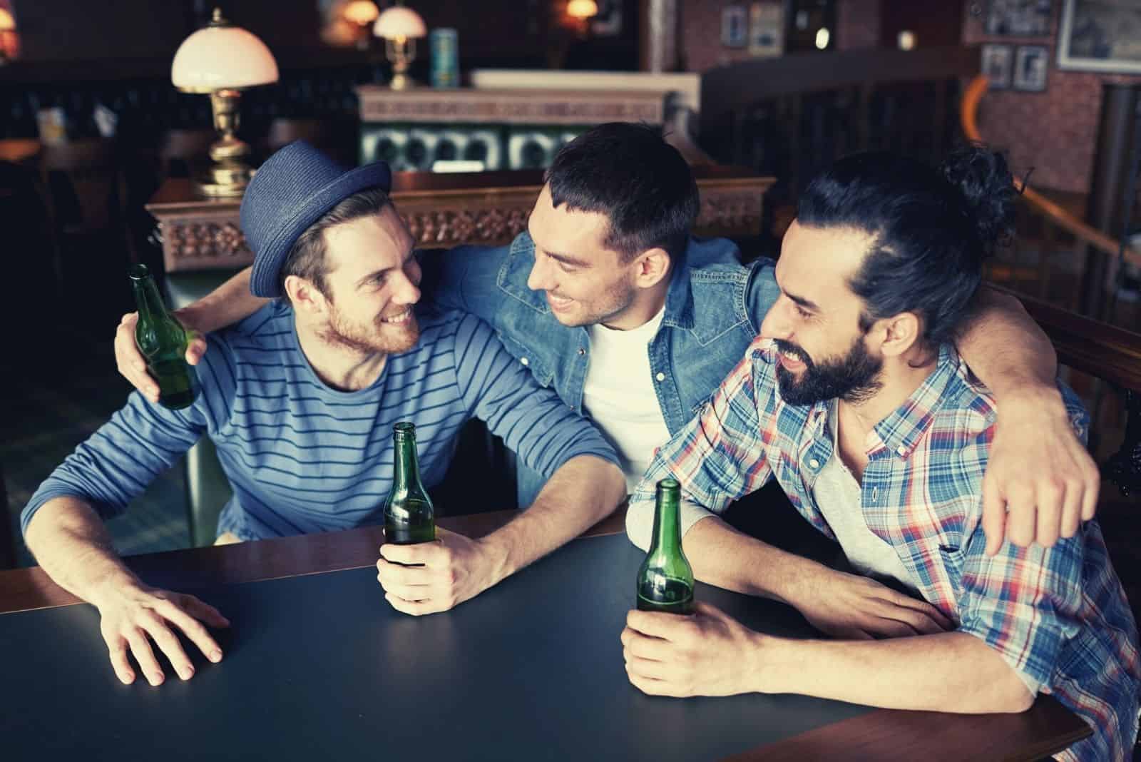 amici maschi felici che bevono birra e stanno insieme