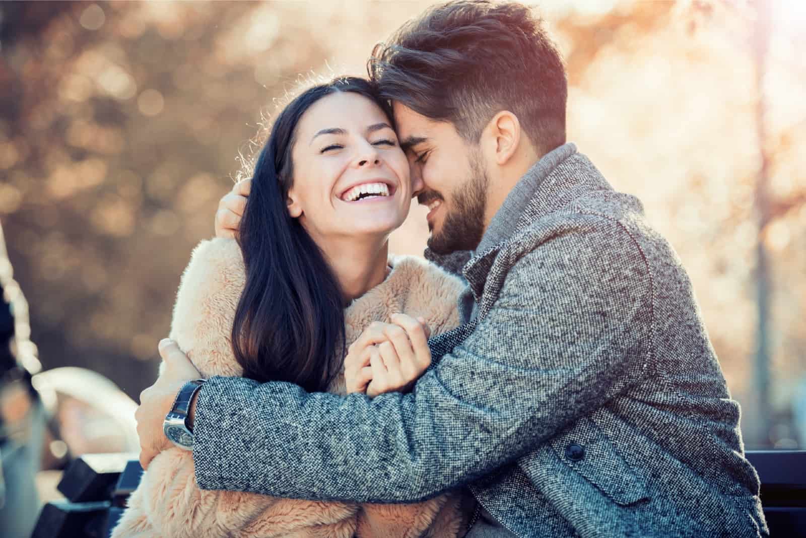 happy man in gray coat hugging woman outdoor