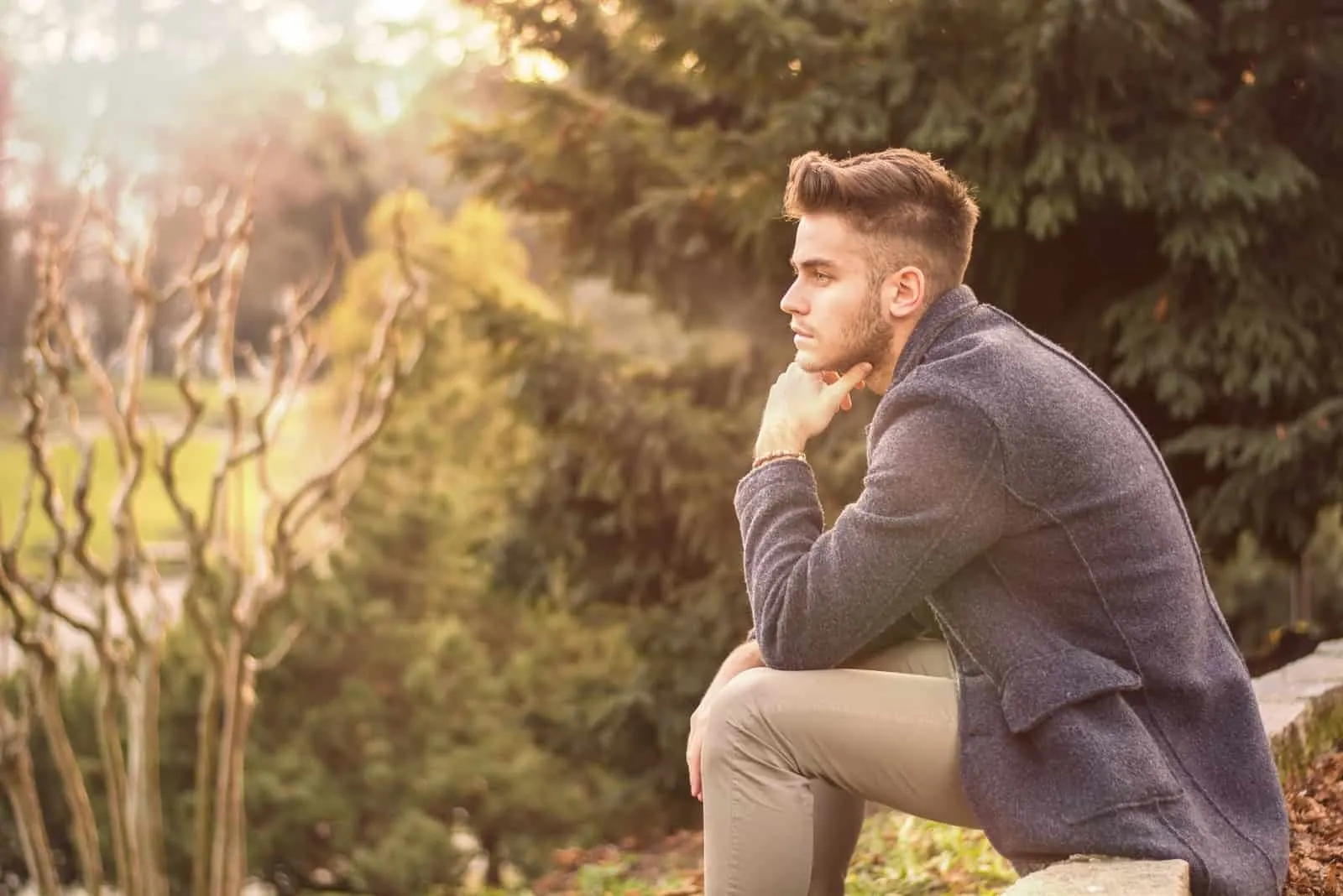 pensive man in gray jacket sitting outdoor