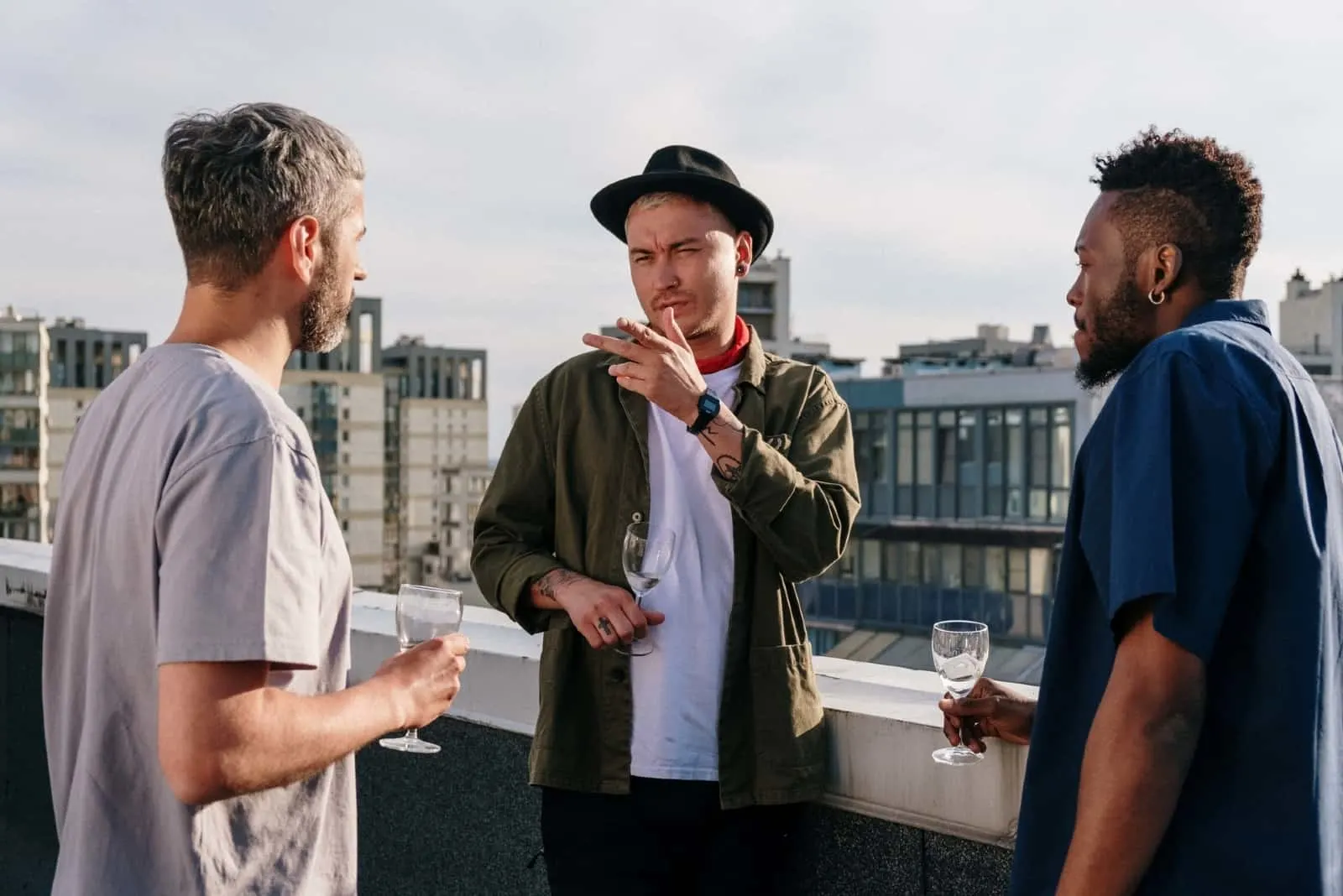 three men talking while standing on rooftop