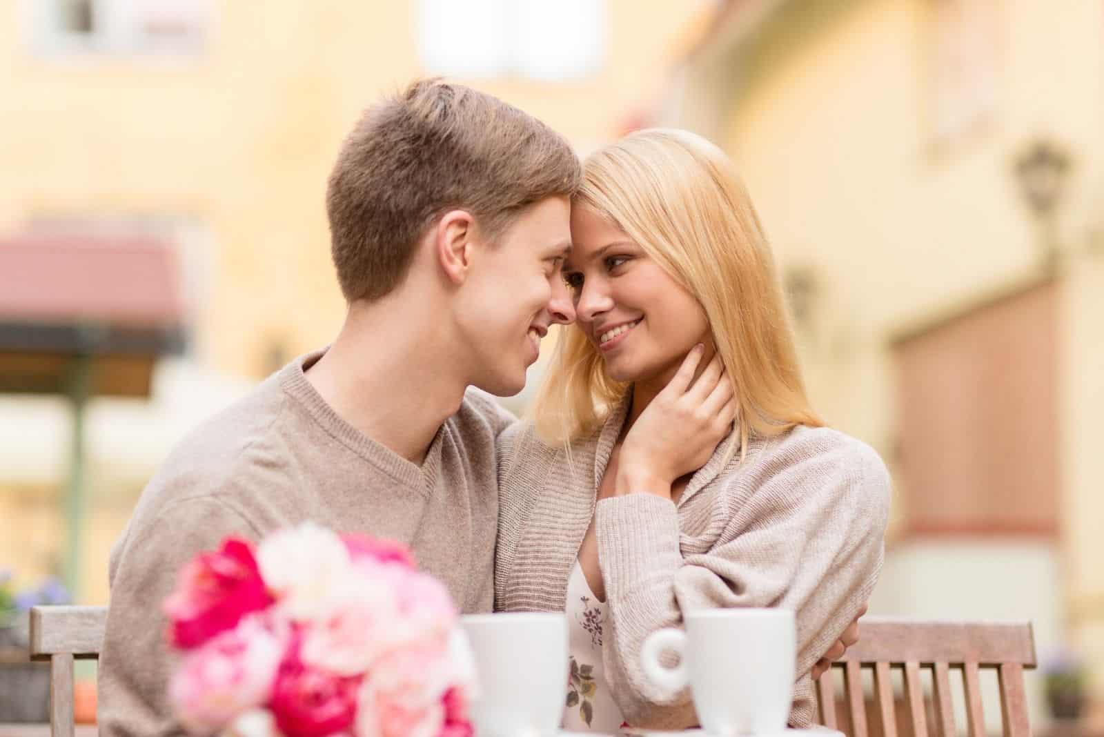 romántica pareja feliz cerca uno del otro durante su cita en un café aireado 