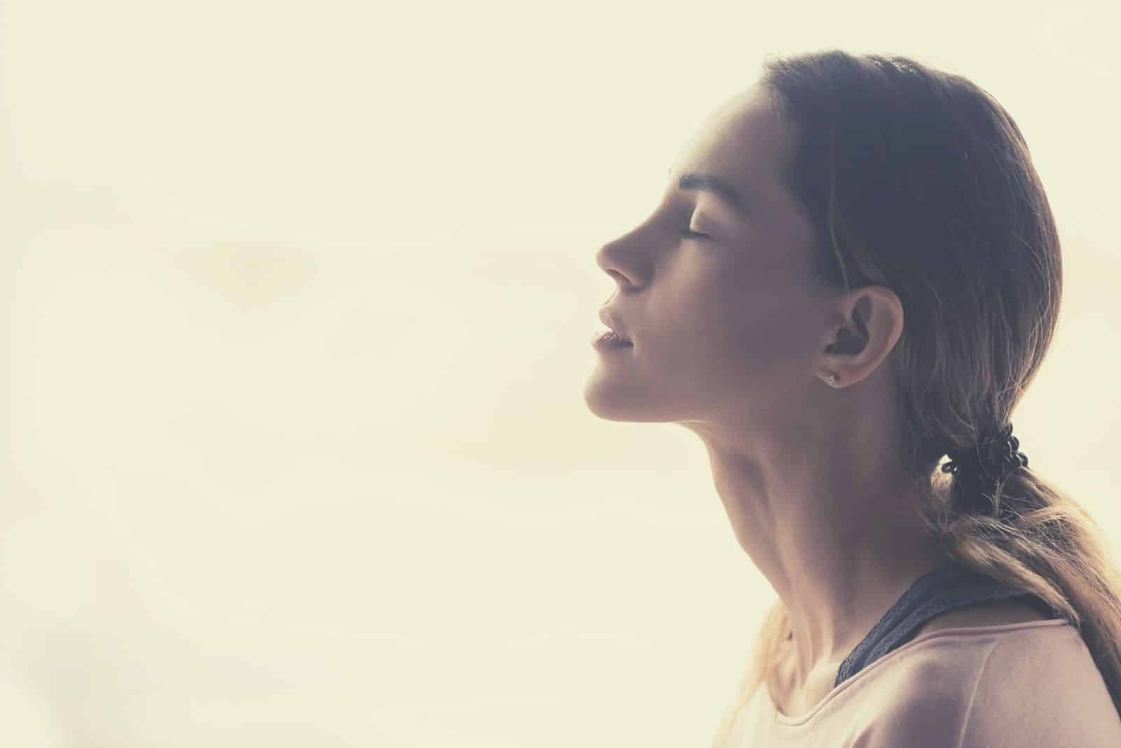 serene young woman meditating taking a deep breath