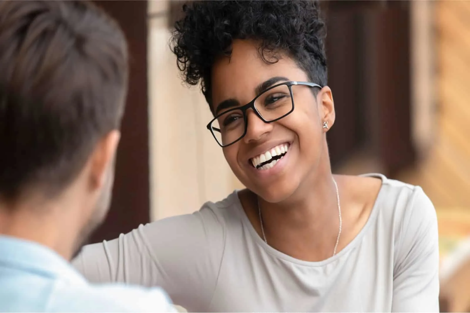 woman with curly hair smiling while looking at man