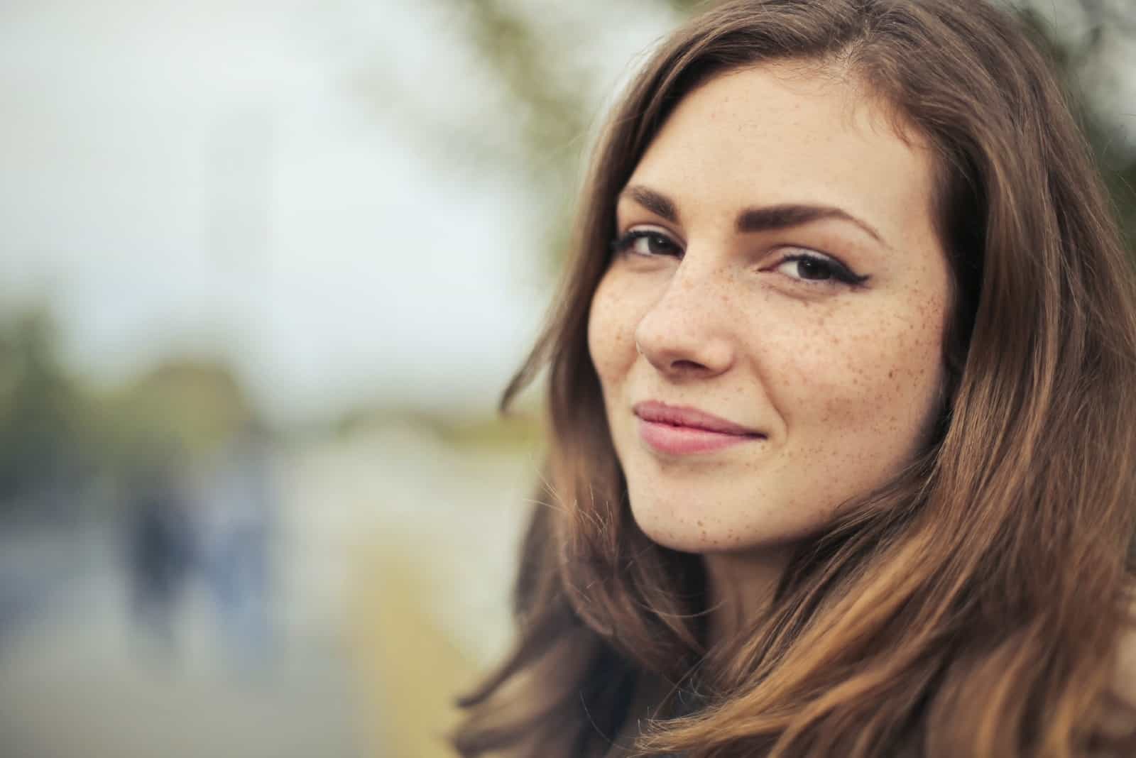 mujer sonriendo de pie al aire libre