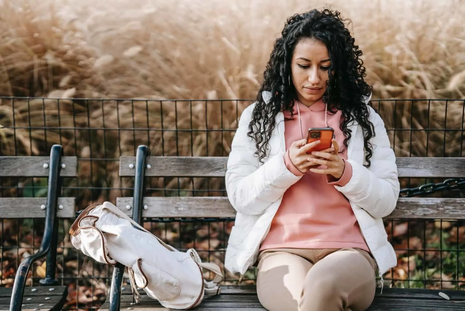 woman using smartphone while sitting on bench