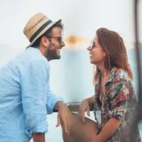 a smiling man and woman look at each other